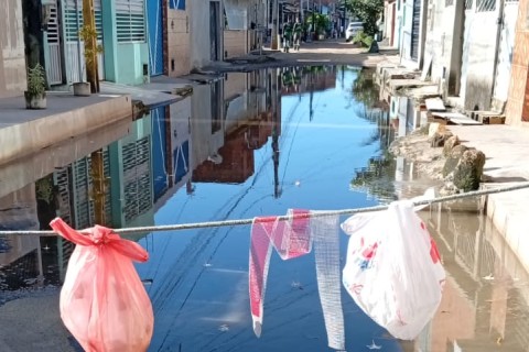 Moradores interditam Rua Pitágoras no Teotônio Vilela após esgoto invadir casas e quintais